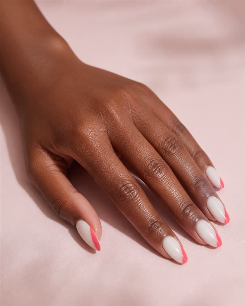 Mão com unhas almond brancas e nail art coral